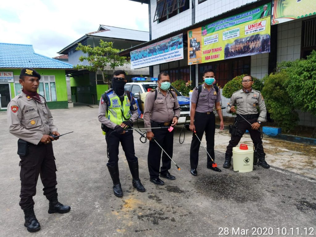 Anggota kepolisian menyemprotkan disinfektan di Ponpes Ushuluddin Singkawang 