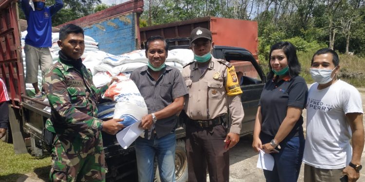 Petugas berfoto bersama sebelum menyerahkan beras bantuan kepada warga tidak mampu