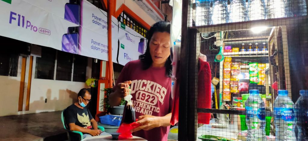 Ewin membungkus kopi pesanan pengunjung