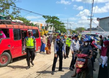 Petugas melakukan pemeriksaan suhu tubuh