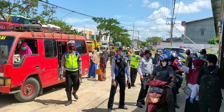 Petugas melakukan pemeriksaan suhu tubuh